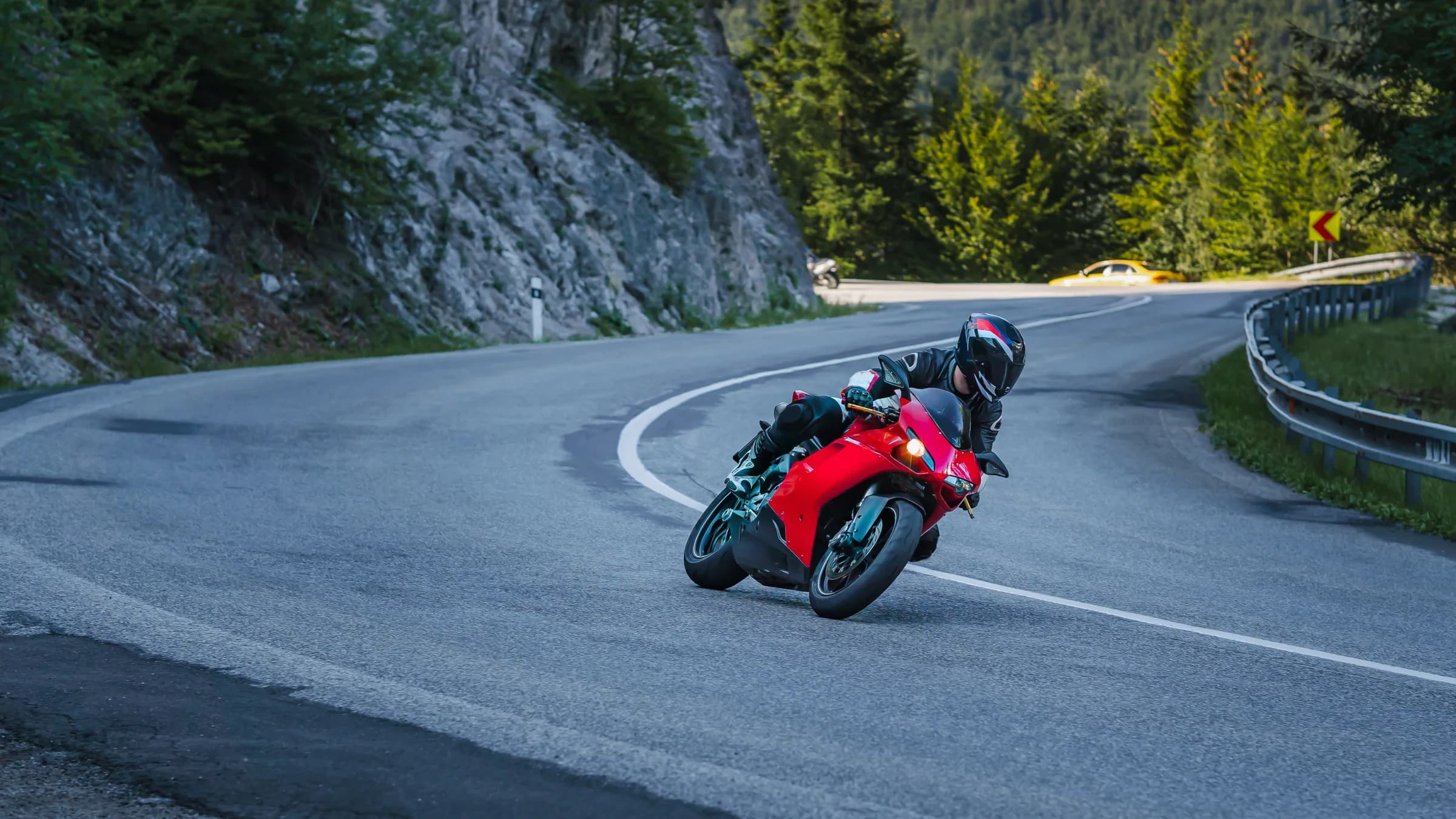 Red sport motorcycle riding a winding mountain road